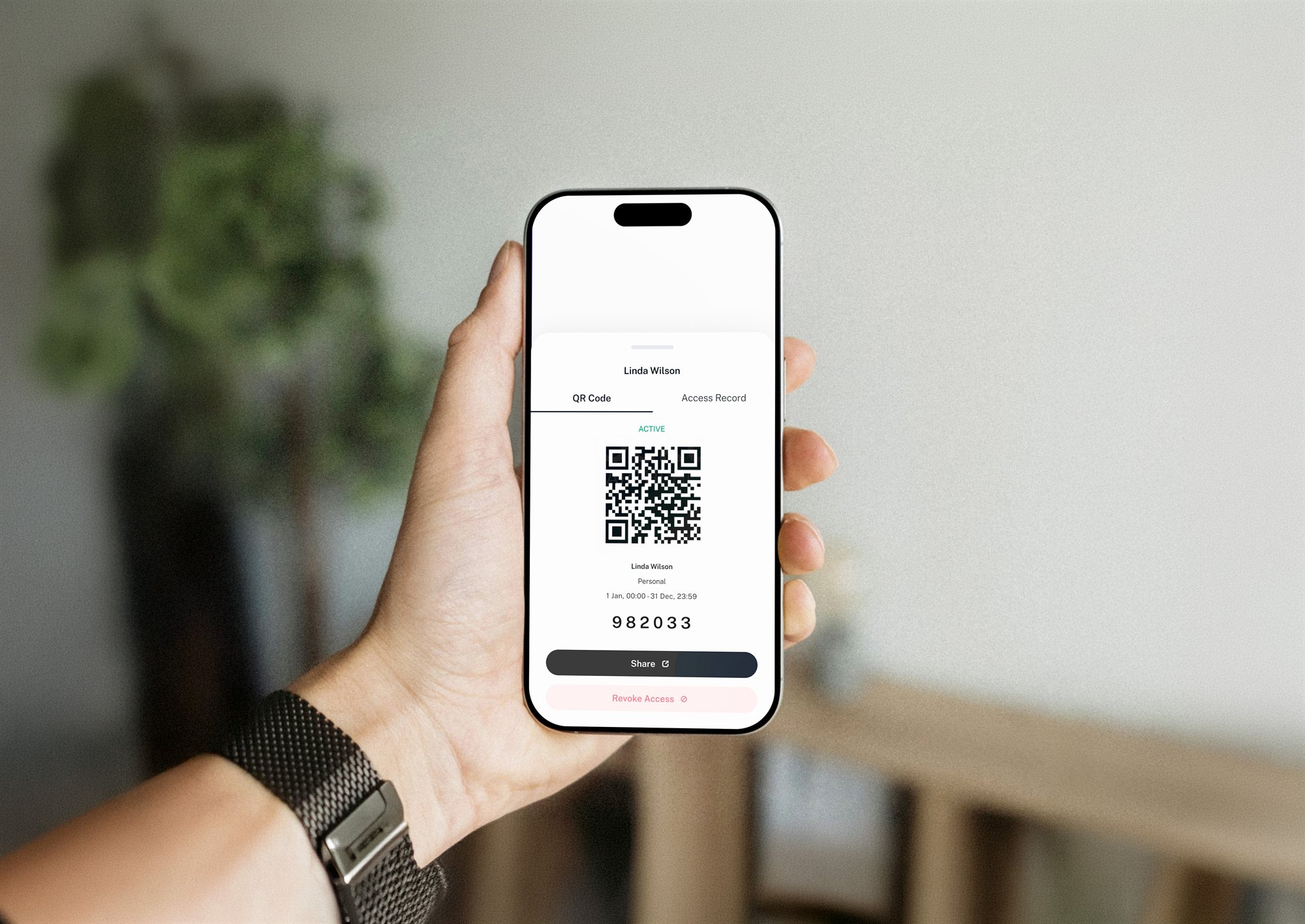 A phone displaying a QR access pass at an entry